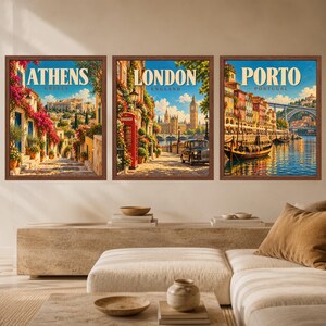 May include: Three framed wall art prints depicting travel scenes. The left print shows Athens, Greece with stone steps and pink flowers. The center print shows London, England with a red phone booth and black taxi. The right print shows Porto, Portugal.