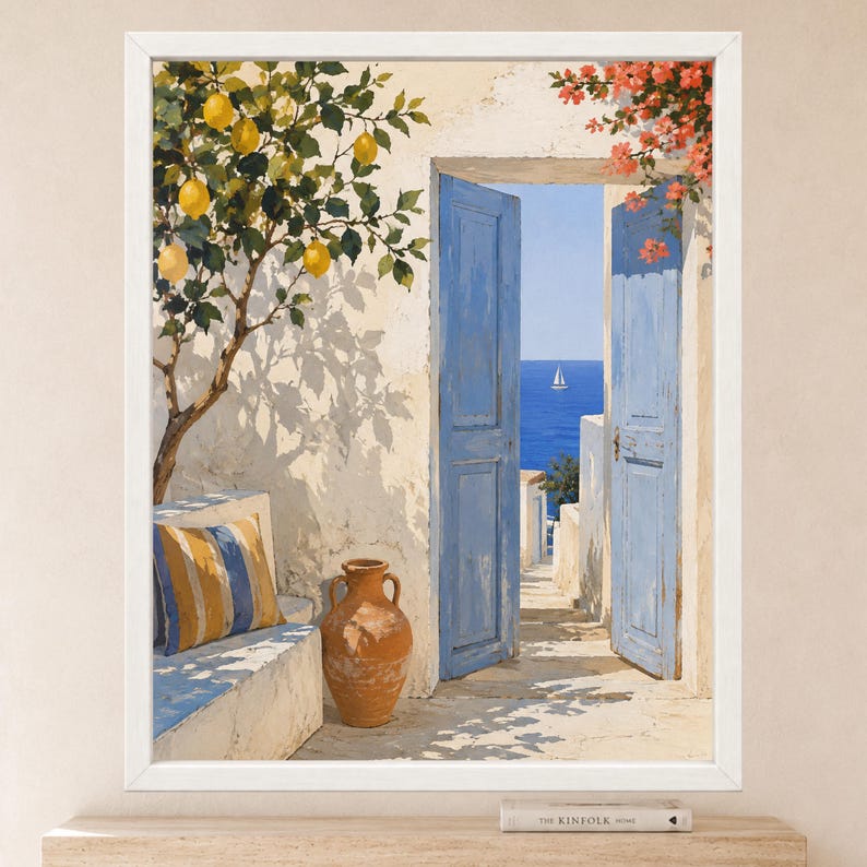 May include: A framed painting depicting a Mediterranean scene with a white wall, a lemon tree, a terracotta vase, and a blue striped cushion on a bench. An open blue door reveals a view of the blue sea with a sailboat under a clear sky.