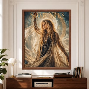Framed Stevie Nicks wall art showing a female rock singer in flowing black and cream lace beneath a large glowing moon, surrounded by stars, clouds and ornate golden celestial details.