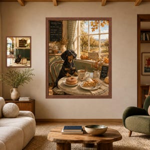 May include: A framed wall art print featuring a black and tan dachshund sitting at a round table with a doughnut, a slice of pie, and a mug labelled Warm Cider. The scene is set in an orchard with autumn trees visible through a window in the background.