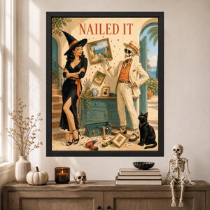 May include: A framed wall art print titled NAILED IT featuring a woman in a black dress and witch hat standing next to a skeleton in a beige suit and fedora. A black cat sits nearby, and tools are scattered on the floor in a room with a blue cabinet.
