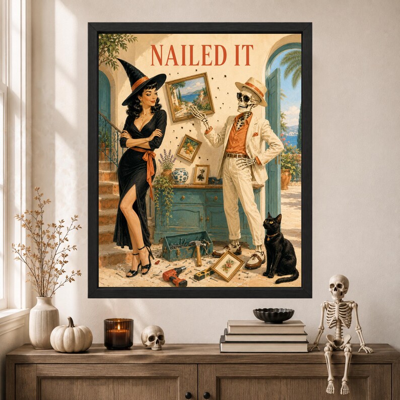 May include: A framed wall art print titled NAILED IT featuring a woman in a black dress and witch hat standing next to a skeleton in a beige suit and fedora. A black cat sits nearby, and tools are scattered on the floor in a room with a blue cabinet.