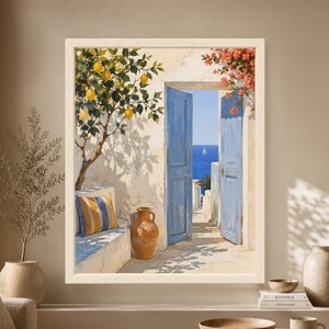 Framed Mediterranean wall art showing open blue doors overlooking the sea, with a lemon tree, terracotta amphora, red bougainvillea, white stone steps and a small sailboat on the horizon.