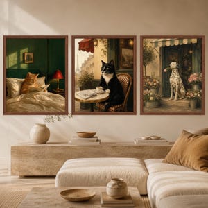 May include: A set of three framed wall art prints. The left print shows an orange cat reading in bed. The center print depicts a black and white cat at a Parisian cafe table. The right print features a Dalmatian dog holding a flower in a shop doorway.