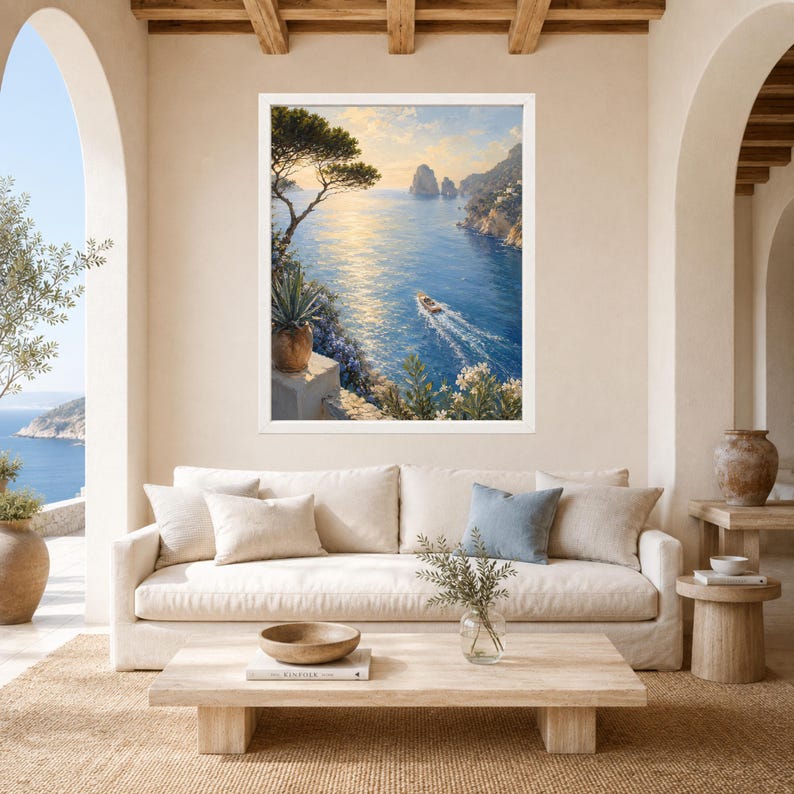 May include: A framed wall art print depicting a coastal landscape with a blue sea, a small motorboat leaving a wake, rocky cliffs, and a golden sunset sky. The scene includes a foreground with a potted agave plant and white flowering bushes.