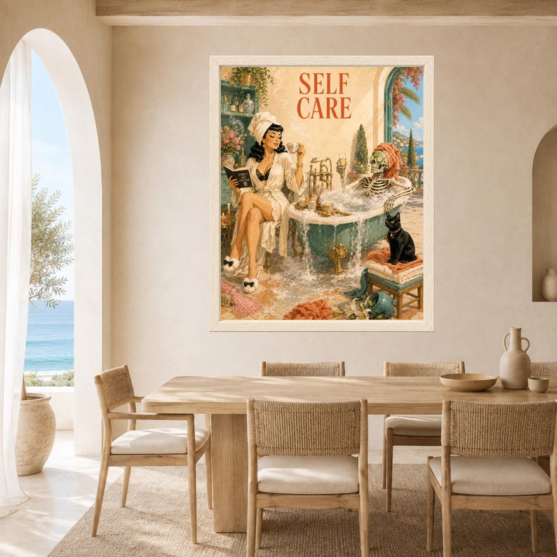 May include: A framed wall art print titled SELF CARE featuring a vintage-style illustration of a person in a white robe reading a book while a skeleton relaxes in a clawfoot bathtub filled with bubbles, accompanied by a black cat on a stool.