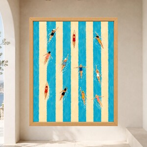 May include: A framed wall art print featuring a top-down view of swimmers in a pool with alternating vertical blue and cream stripes. The swimmers wear various colored swimsuits and caps, positioned within the blue lanes of the pool.