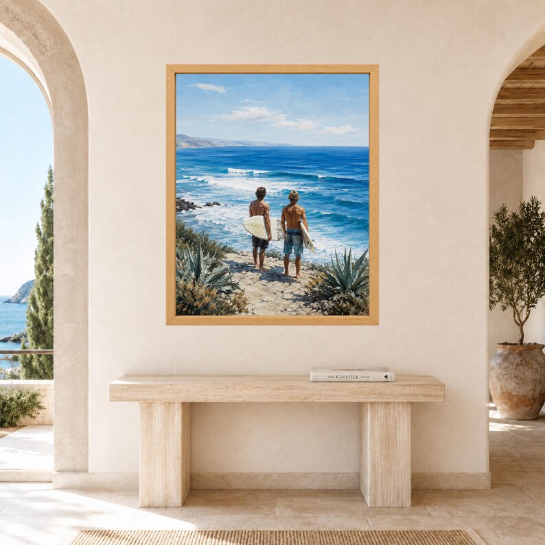 Puede incluir: Una impresi&oacute;n art&iacute;stica enmarcada que muestra a dos personas de pie en un acantilado frente a un oc&eacute;ano azul mientras sostienen tablas de surf. La escena presenta vegetaci&oacute;n costera, olas y un cielo despejado, en un estilo pict&oacute;rico realista.