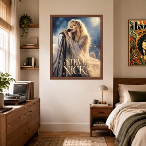 Puede incluir: Un p&oacute;ster de pared enmarcado que presenta una fotograf&iacute;a de Stevie Nicks cantando en un micr&oacute;fono sobre un escenario. La cantante tiene el cabello largo y rubio y viste una prenda fluida de color claro. El nombre STEVIE NICKS est&aacute; en letras doradas.
