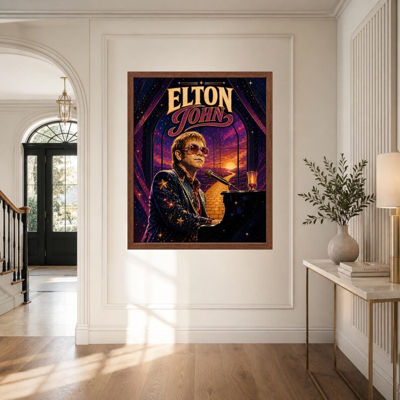 May include: A framed wall art print featuring a stylized illustration of Elton John wearing star-patterned clothing and sunglasses while playing a black piano. The background displays a sunset over a yellow brick road with the text Elton John.