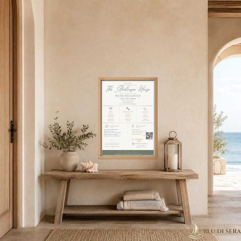 Op de afbeelding: Een ingelijst rechthoekig gasteninformatiebord met een lichte houten rand, voorzien van de tekst The Anderson House, We're Delighted You're Here, samen met iconen voor wifi, inchecken, contact, huisregels en een QR-code voor lokale info.