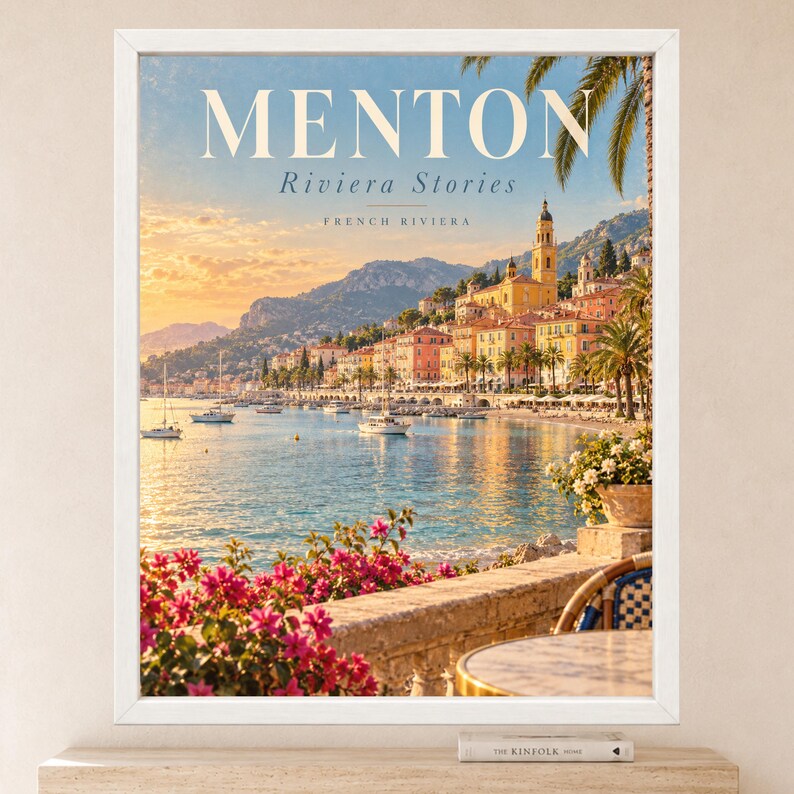 May include: A framed travel poster featuring the text MENTON Riviera Stories FRENCH RIVIERA. The image displays a coastal town with colorful buildings, a church tower, sailboats on blue water, palm trees, and bright pink bougainvillea flowers.
