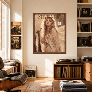 Może przedstawiać: Oprawiony wydruk ścienny przedstawiający portret Stevie Nicks w odcieniach sepii z długimi, falowanymi włosami, ubraną w zwiewny str&oacute;j z frędzlami i trzymającą mikrofon, z napisem Stevie Nicks wydrukowanym ciemną czcionką szeryfową u g&oacute;ry.