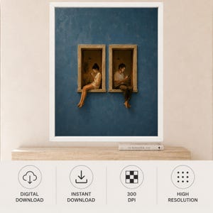Op de afbeelding: Een ingelijste kunstprint met een diepblauwe, getextureerde muur met twee rechthoekige ramen. In elk raam zit een persoon die naar een mobiel apparaat kijkt. De print staat op een houten plank naast een boek met de titel The Kinfolk.
