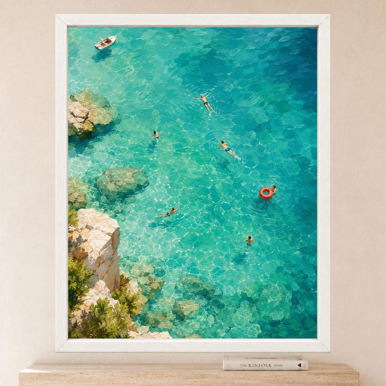 Puede incluir: Una l&aacute;mina de arte mural enmarcada que muestra una vista a&eacute;rea de un mar turquesa con acantilados rocosos a la izquierda. Varias personas nadan en el agua clara, una con un flotador naranja brillante, y un peque&ntilde;o barco blanco flota cerca.