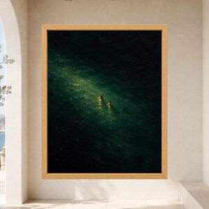 May include: A framed wall art print featuring a dark, deep green ocean scene with two small figures swimming in a bright, diagonal shaft of sunlight that cuts across the water's surface, set within a light-toned wooden frame.