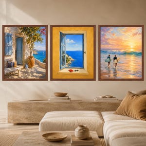 May include: A set of three framed wall art prints featuring coastal scenes. The left print shows a Mediterranean terrace with a lemon tree and blue door. The center print depicts an open window overlooking the sea. The right print shows two surfers.