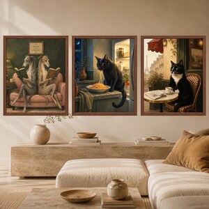May include: Three framed wall art prints featuring anthropomorphic animals. The left print shows two grey dogs reading books on a pink sofa. The center print depicts a black cat eating spaghetti in a kitchen. The right print shows a tuxedo cat at a cafe.