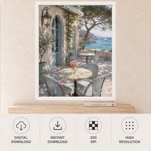 May include: A framed wall art print depicting a Mediterranean terrace scene with stone arches, blue-toned wicker chairs, and round tables. A vase with pink flowers sits on a table, while a view of the sea with a sailboat is visible in the distance.