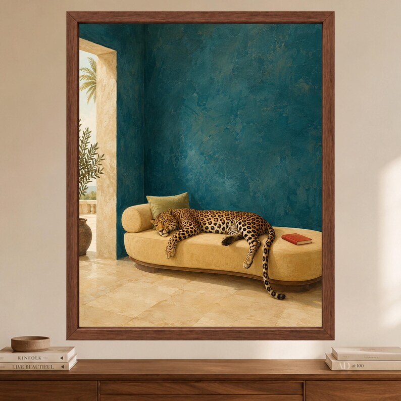 May include: A framed wall art print featuring a leopard resting on a long, curved yellow bench. The scene is set against a textured teal wall and a stone floor, with a small red book on the bench and a green pillow behind the leopard's head.