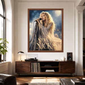 Puede incluir: Una impresi&oacute;n de arte de pared enmarcada que presenta un retrato de Stevie Nicks cantando en un micr&oacute;fono. La imagen muestra a Nicks con cabello rubio largo, vistiendo una prenda fluida de color claro, sobre un fondo oscuro y atmosf&eacute;rico con una luna.