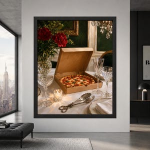 Framed quirky pizza wall art showing an open cardboard pizza box on an elegant white linen dining table surrounded by crystal glasses, silver serving pieces and deep red flowers.