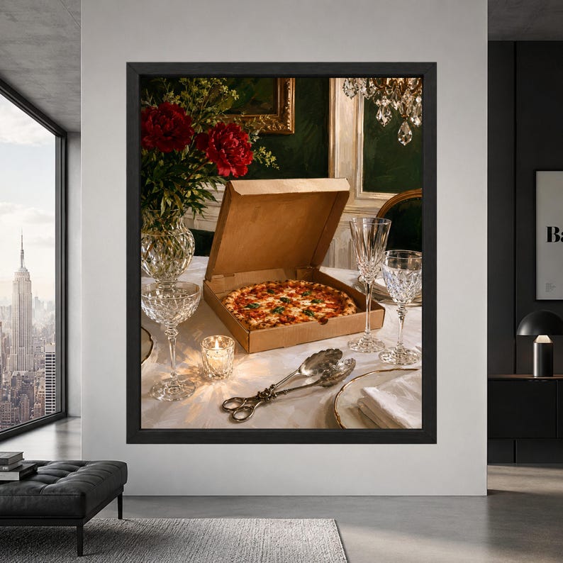 Framed quirky pizza wall art showing an open cardboard pizza box on an elegant white linen dining table surrounded by crystal glasses, silver serving pieces and deep red flowers.
