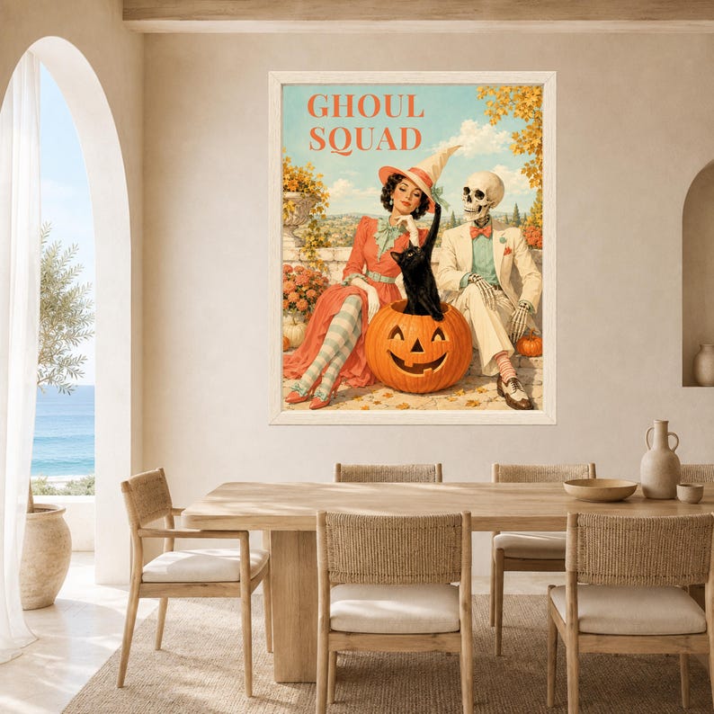 May include: A framed wall art print titled GHOUL SQUAD featuring a vintage-style illustration of a person in a witch hat and a skeleton in a suit sitting with a black cat inside a large carved jack-o'-lantern pumpkin against a landscape.