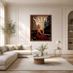 May include: A framed wall art print featuring a portrait of a person in a dark red satin dress sitting at a black grand piano. The word SADE is printed in large, light-colored capital letters at the top of the image against a dark background.