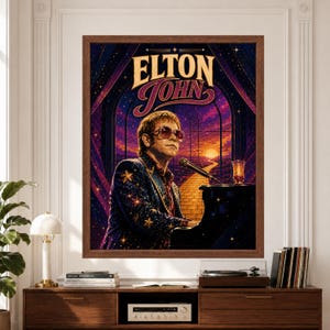 Framed Elton John wall art featuring the singer at a black grand piano wearing oversized glasses and a star-covered jacket in a purple celestial scene with golden stars, sunset and winding road.