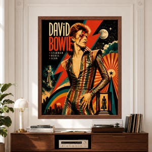 Framed David Bowie wall art featuring Bowie in a striped glam rock stage suit with lightning-bolt makeup, bold Starman graphics, stars, moon imagery and colorful retro 1970s poster design.