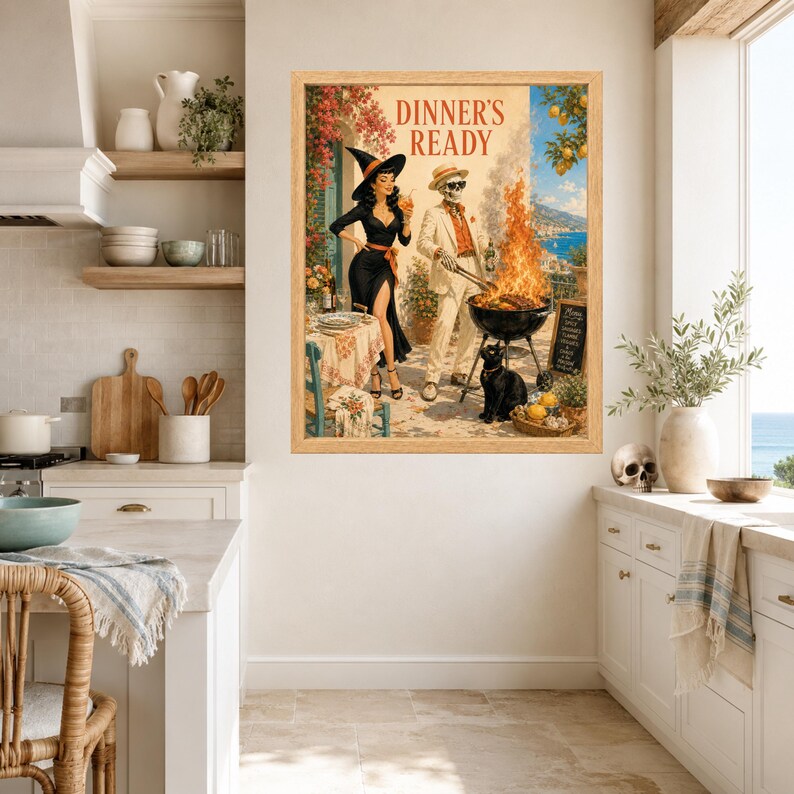 May include: A framed wall art print titled DINNER'S READY featuring a woman in a black dress and witch hat standing next to a skeleton in a white suit grilling food on a charcoal barbecue. A black cat sits nearby on a patio with a coastal view.