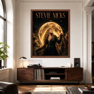 May include: A framed wall poster featuring a portrait of Stevie Nicks in a black lace dress against a large, glowing full moon and starry night sky. The text STEVIE NICKS and WILD HEART GYPSY SOUL is printed in gold at the top of the dark, atmospheric image.