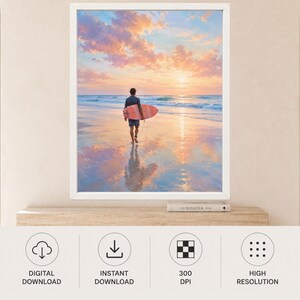 May include: A framed wall art print featuring a person walking on a wet sandy beach at sunset while carrying a surfboard. The sky is filled with soft pink and orange clouds, and the ocean waves are visible in the distance under the bright sun.