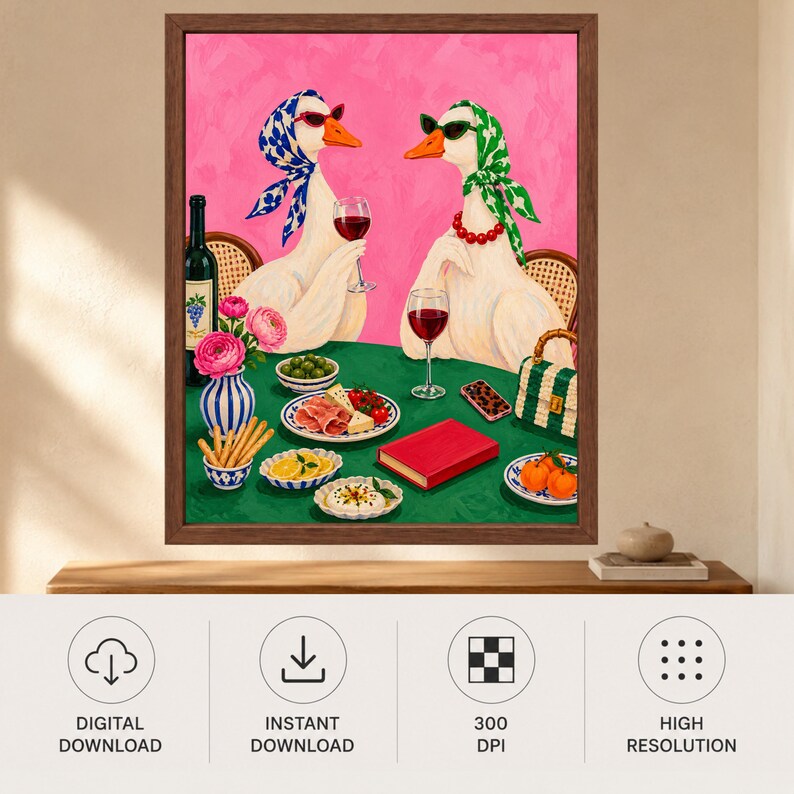 May include: A framed wall art print featuring two white geese wearing headscarves and sunglasses, sitting at a green table with wine glasses, a bottle of wine, a vase of pink flowers, breadsticks, olives, cheese, fruit, and a red book.