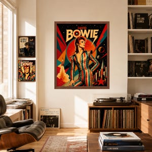 May include: A framed wall art print featuring a stylised illustration of David Bowie in a striped jumpsuit against a vibrant, geometric background with a rocket, planets, and a red star. The text DAVID BOWIE is printed in bold letters at the top.