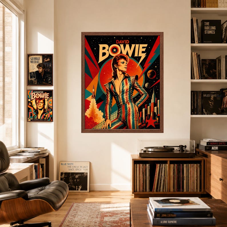 May include: A framed wall art print featuring a stylised illustration of David Bowie in a striped jumpsuit against a vibrant, geometric background with a rocket, planets, and a red star. The text DAVID BOWIE is printed in bold letters at the top.