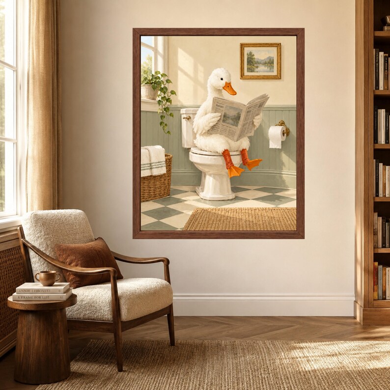 May include: A framed wall art print depicting a white duck with orange feet sitting on a white toilet in a bathroom, reading a newspaper. The bathroom features green wainscoting, a checkered floor, a wicker basket, and a small framed landscape painting.