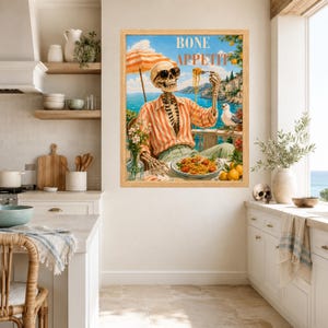 Peut inclure: Une impression d'art encadr&eacute;e repr&eacute;sentant un squelette portant des lunettes de soleil et une chemise ray&eacute;e orange, mangeant des spaghettis &agrave; une table c&ocirc;ti&egrave;re. Le texte BONE APPETIT est affich&eacute; au-dessus. La sc&egrave;ne inclut un go&eacute;land et des citrons.