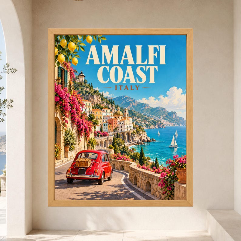 May include: A framed wall art print featuring a coastal Italian landscape with a red vintage car on a winding road, bright pink bougainvillea flowers, yellow lemons, and sailboats on the blue sea, with the text AMALFI COAST ITALY at the top.
