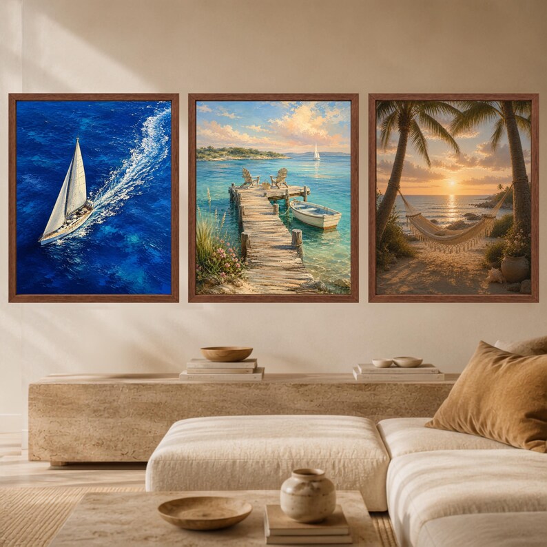 May include: A set of three framed wall art prints featuring coastal scenes. The left print shows a sailboat on deep blue water, the center print depicts a wooden pier with chairs and a boat, and the right print displays a hammock between palm trees.