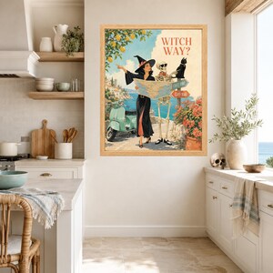 Puede incluir: Una l&aacute;mina de arte enmarcada titulada WITCH WAY? que presenta una ilustraci&oacute;n de estilo vintage de una bruja con vestido negro y un esqueleto con gafas de sol mirando un mapa. Tambi&eacute;n se muestran un gato negro, un scooter verde claro y se&ntilde;ales.
