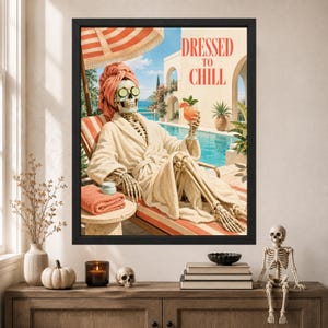 May include: A framed wall art print featuring a skeleton wearing a beige bathrobe and a peach-colored towel on its head, with cucumber slices over its eyes. The skeleton holds an orange cocktail by a pool under the text DRESSED TO CHILL.