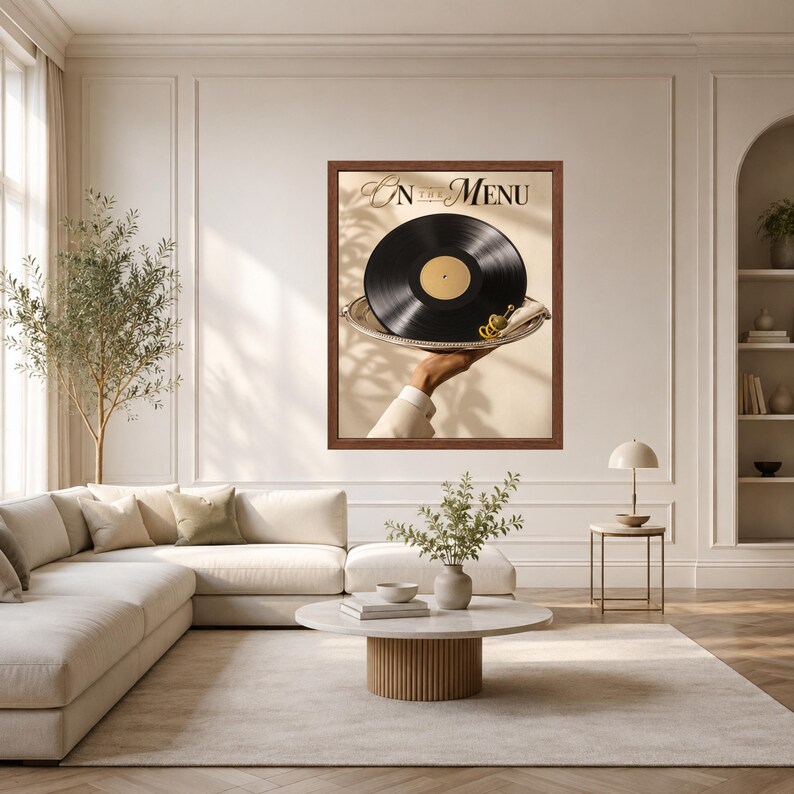 May include: A framed wall art print featuring a black vinyl record served on a silver platter with a green olive garnish. The text ON THE MENU is printed in black at the top. The image shows a hand holding the platter against a beige background.