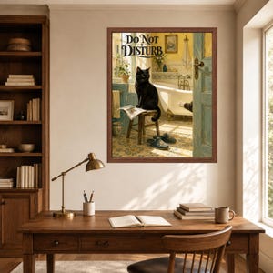 May include: A framed wall art print featuring a black cat sitting on a wooden stool in a bathroom, reading a newspaper. The text DO NOT DISTURB is printed at the top. The scene includes a white bathtub, blue door frame, and patterned floor tiles.