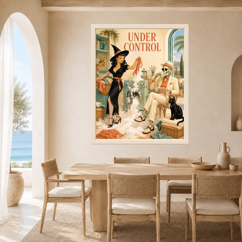 May include: A framed wall art print titled UNDER CONTROL featuring a retro-style illustration of a person in a witch hat doing laundry next to a skeleton sitting in a chair drinking coffee with a black cat nearby, all set in a sunlit room.