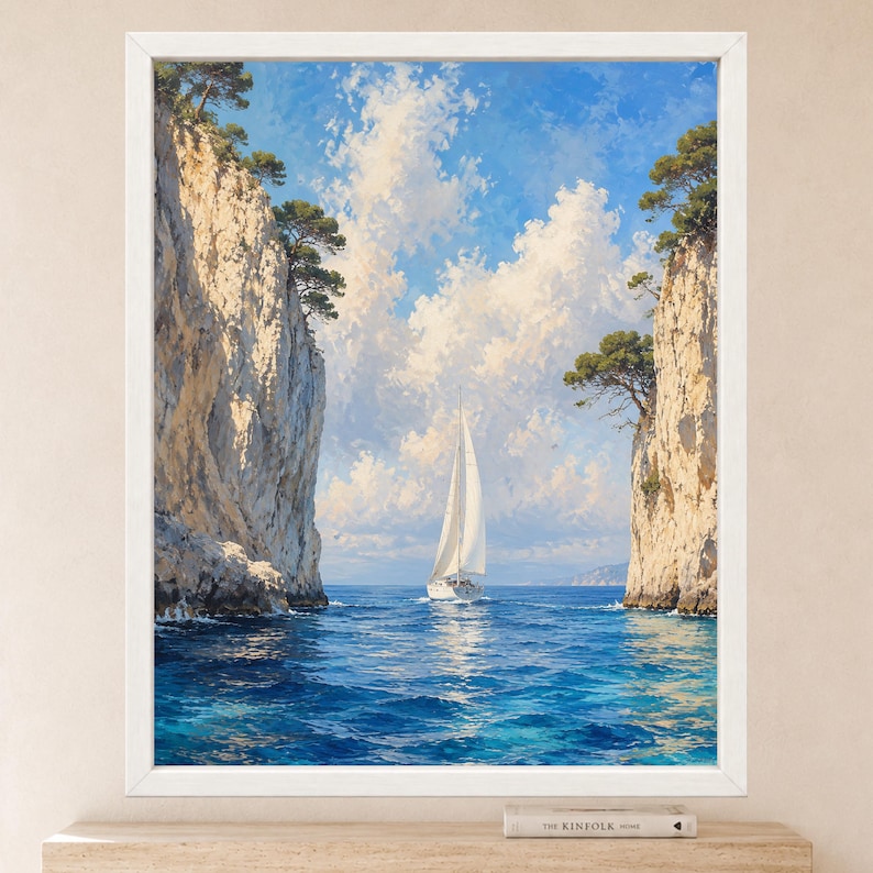May include: A framed wall art print depicting a white sailboat navigating through a narrow passage between two tall, light-colored rocky cliffs. The scene features deep blue water, a bright blue sky with white clouds, and green trees atop the cliffs.