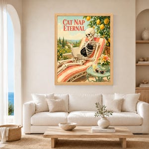 May include: A framed wall art print titled CAT NAP ETERNAL featuring a skeleton lounging on a striped deck chair in a lemon grove, reading a book with a black cat on its lap, next to a small green table with a drink and sunglasses.