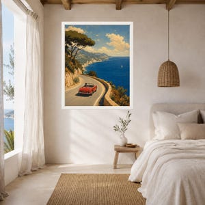 May include: A framed wall art print depicting a red convertible driving along a winding coastal road overlooking a deep blue sea. The scene features a rocky cliffside with green trees, a clear sky with light clouds, and a distant sailboat.