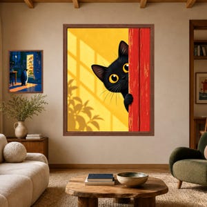 May include: A framed wall art print featuring a black cat with large yellow eyes peeking from behind a bright red wooden door against a yellow background with leaf shadows. A smaller framed print of a penguin by a refrigerator is also visible.
